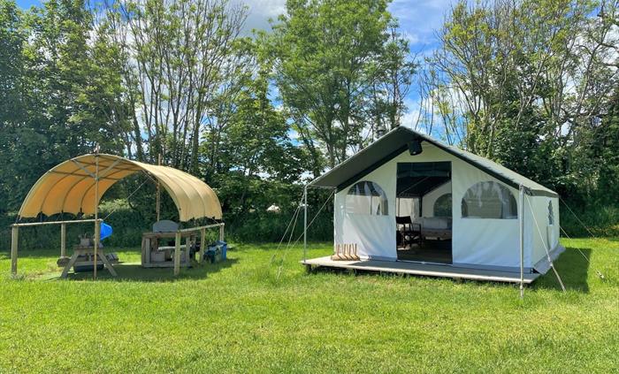 Pioneer Glamping tents come with their own covered kitchen positioned around the wildflower meadow with plenty of space for games and hanging out side